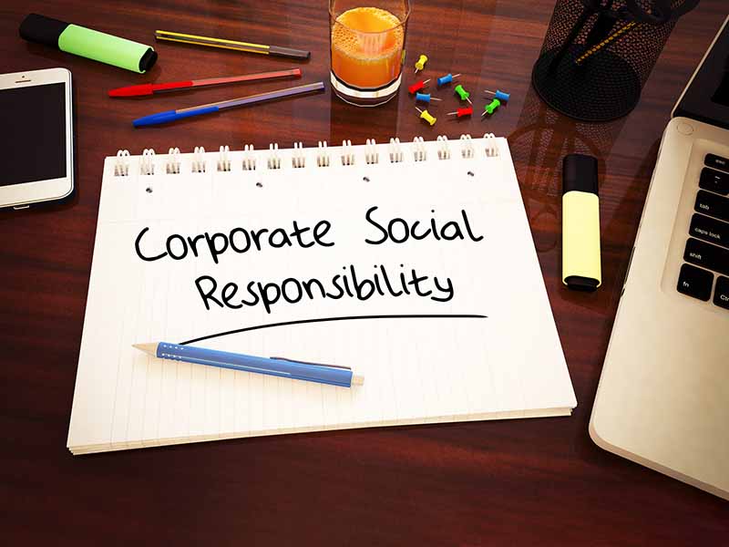 Corporate Social Responsibility - handwritten text in a notebook on a desk